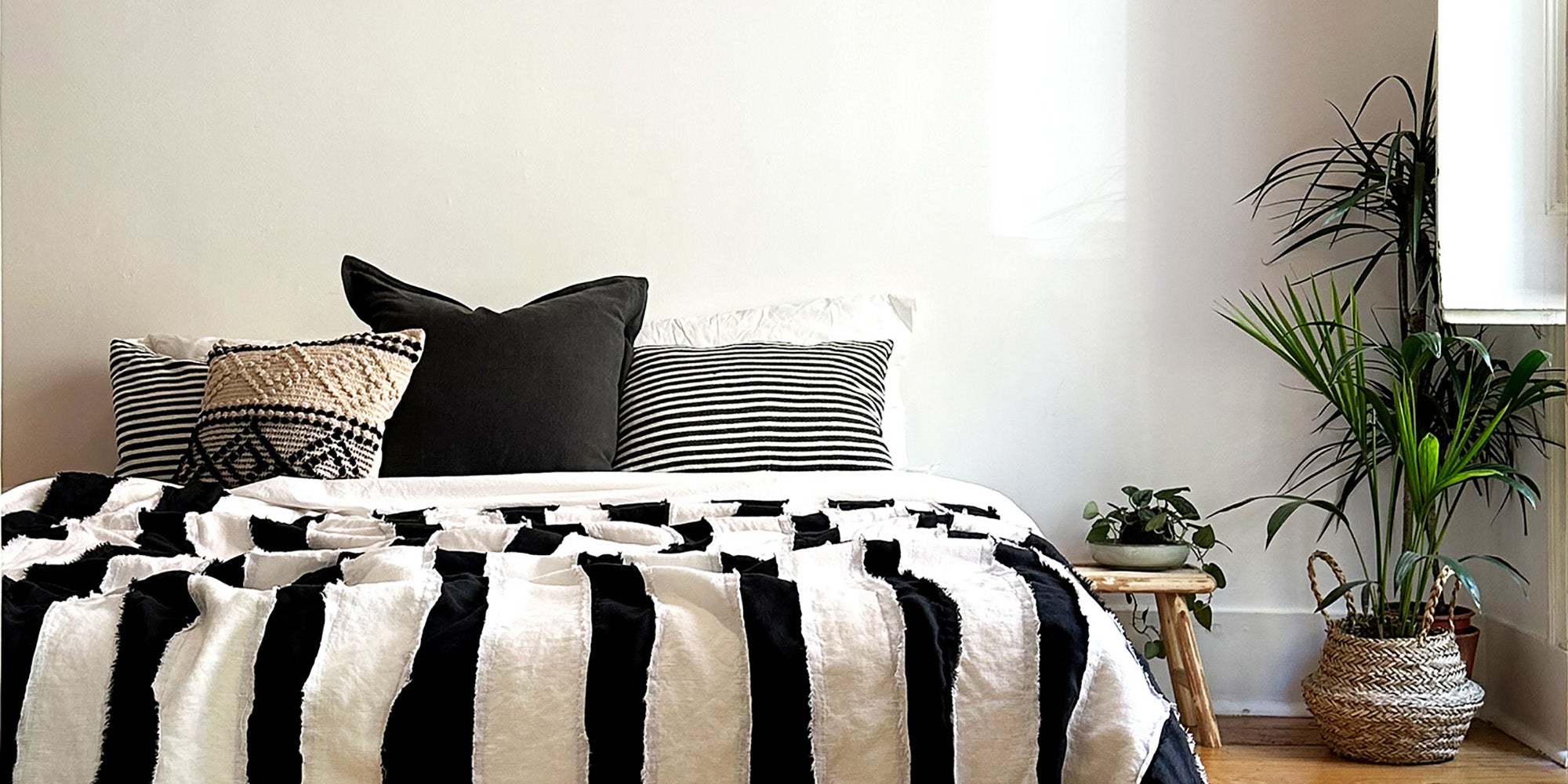 handmade linen striped bedcover and monochrome cotton cushions